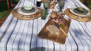 An outdoor dining table set with plates, cutlery, and a bottle of wine, surrounded by greenery and trees. - "Nouveau, a true haven of peace, close to Saint-Emilion, Bordeaux. (Saint-Vincent-de-Pertignas)