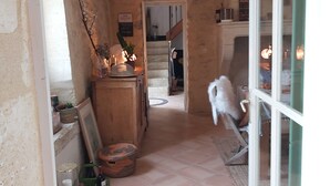 A narrow hallway with a tiled floor, wooden beams on the ceiling, and a door leading to another room. - "Nouveau, a true haven of peace, close to Saint-Emilion, Bordeaux. (Saint-Vincent-de-Pertignas)