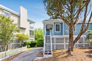 A two-story house with a covered porch and a white picket fence.