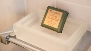 A bar of Damana soap with nourishing olive oil on a white soap dish in a bathroom. - Eleia Seafront VIlla with Private Pool & Sea View (Lesvos)