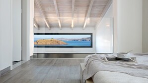 A modern bedroom with a large window, a bed, and a view of a coastal landscape. - Eleia Seafront VIlla with Private Pool & Sea View (Lesvos)