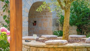 A stone circular seating area with cushions, a tree, and a stone wall in the background. - Villa Olea in Barat  - Haus für 6-8 Personen (Kanfanar)