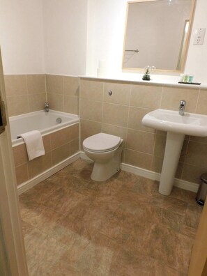 Bathtub, hair dryer, towels, shampoo