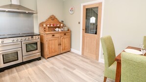 A kitchen with a stove, oven, and wooden cabinet. - Willows (Corbridge)