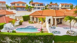 Um bairro residencial com várias casas, piscina e jardins bem cuidados.