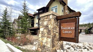 A stone pillar with a sign for Trailhead Lodges.