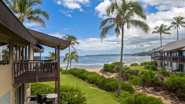Une propriété située en bord de mer, dotée d’une terrasse couverte et offrant une vue sur l’océan.
