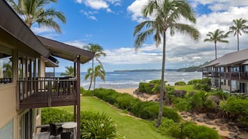A beachfront property with a covered deck and a view of the ocean.