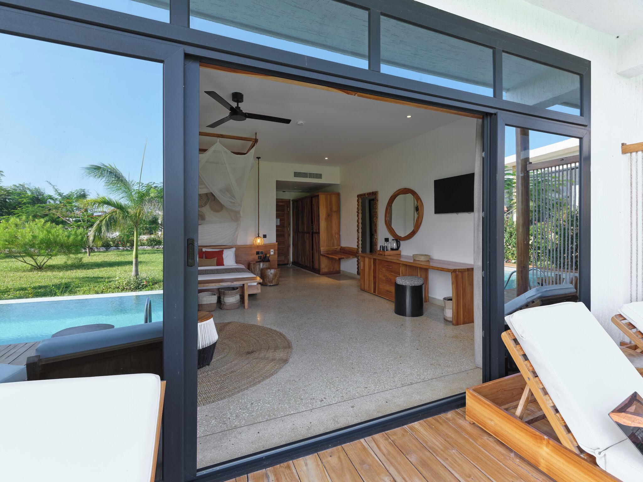 Un intérieur moderne avec une piscine, des meubles en bois et une vue sur l’ext érieur.