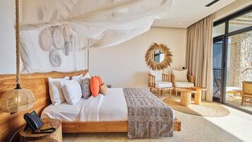 A spacious bedroom with a large bed, a wooden headboard, a hanging canopy, and a stone wall.