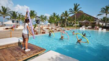 A pool area with lounge chairs, palm trees, and a wooden deck.