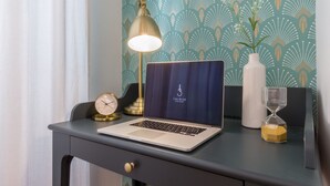A laptop on a desk with a clock, a lamp, and an hourglass. - Casa dei Liuti (Alghero)