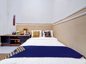 A hotel room with a bed, a desk, and a nightstand. - Spot On 91425 Mekargalih Homestay Syariah (Mekargalih)