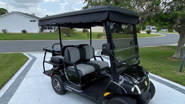 A black golf cart parked on a driveway. - 427 Santa Clara Cir (Lady Lake)