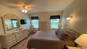 A bedroom with a bed, dresser, chair, and a ceiling fan. - 427 Santa Clara Cir (Lady Lake)