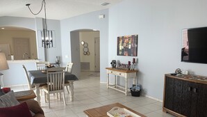 A living room with a coffee table, sofa, and a TV mounted on the wall. - 2066 Duval Ct (The Villages)