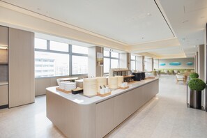 A modern kitchen area with a central island, large windows, and a view of the city. - Ji Hotel Shenzhen Huaqiang North Electronic Buildi (Shenzhen)