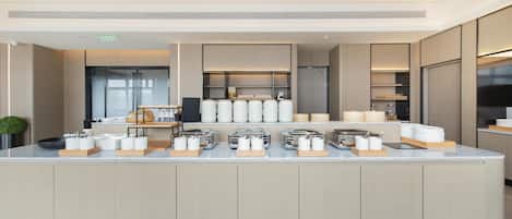 A modern kitchen with a central island, equipped with various appliances and utensils.