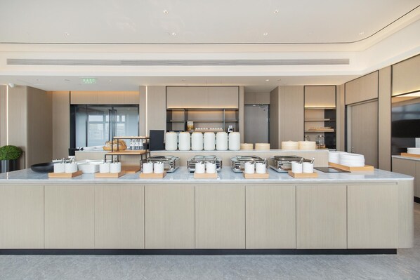 A modern kitchen with a central island, equipped with various appliances and utensils. - Ji Hotel Shenzhen Huaqiang North Electronic Buildi (Shenzhen)