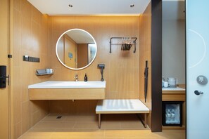 A modern bathroom with a wooden vanity, a round mirror, a towel rack, and a small refrigerator. - Ji Hotel Shenzhen Huaqiang North Electronic Buildi (Shenzhen)