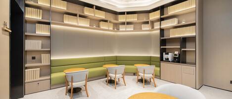 A modern library with bookshelves, seating, and tables.