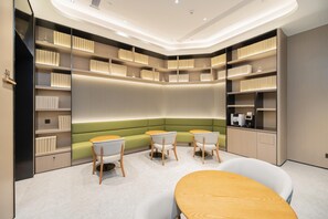 A modern library with bookshelves, seating, and tables. - Ji Hotel Shenzhen Huaqiang North Electronic Buildi (Shenzhen)