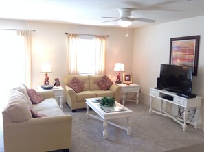 Villa, varias camas, lanai, vista al jardín | Área de sala de estar | Televisión 