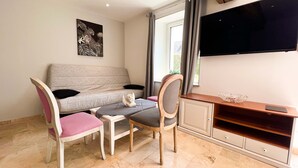 A compact living space with a sofa, two chairs, a small table, a cabinet, and a television. - BIG HOUSE N°6 (Ferrières-la-Verrerie)