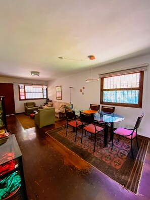 Un amplio espacio de sala con una mesa de comedor, sillas, un sofá y una mesita de centro.