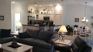 Ein modernes Wohnzimmer mit Sofa, Couchtisch und Essbereich mit Tisch und Stühlen.