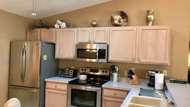 A modern kitchen with stainless steel appliances, wooden cabinets, and a skylight. - 2816 Burgos Dr (The Villages)