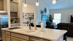 A modern kitchen with a central island, stainless steel appliances, and pendant lighting. - 2498 Lynette Avenue (Wildwood)