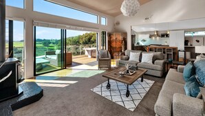 A spacious living area with a large sliding glass door leading to an outdoor patio, a cozy seating area with a fireplace, and a modern kitchen with ample counter space.