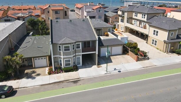 A residential area with houses, a road, and a view of the ocean. - Game room, hot tub, 20 min to SF, beach 1 block away (Pacifica)