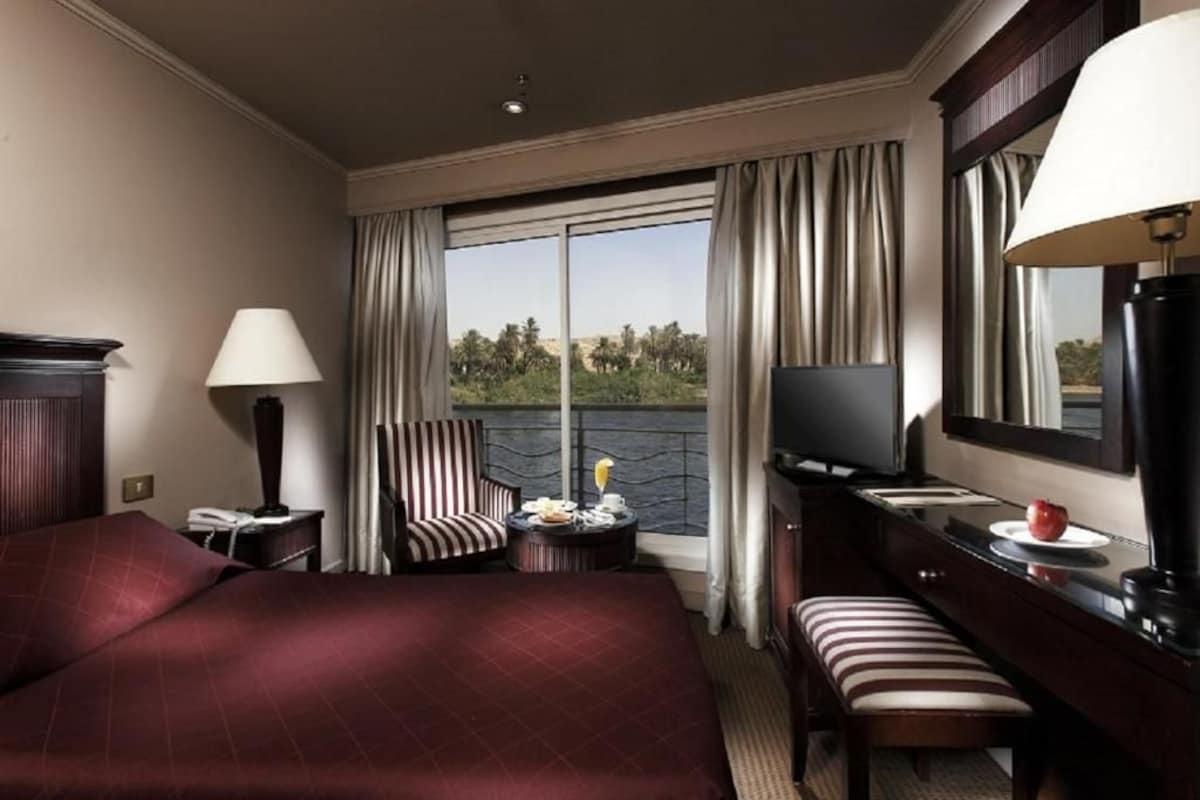 Una camera d'albergo con un letto grande, una scrivania, una TV e vista sull'esterno.