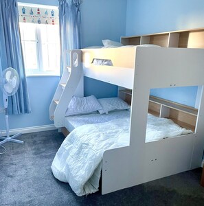 A bunk bed with a white fan and curtains in a room with blue walls. - Stunning Coastal Cottage - Sleeping 4 in 2 Bedrooms - Pool and Beach Access Included. (Filey)