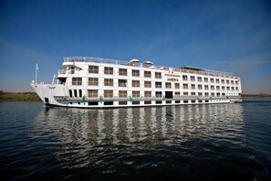 Um grande cruzeiro fluvial com vários andares, varandas e o nome "STEIGENBERGER MINERVA" visível na lateral.