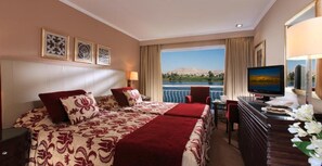 Une chambre d’hôtel équipée d’un lit, d’un bureau, d’une télévision et offrant une vue sur une étendue d’eau.