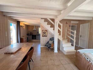 Una cocina amplia con comedor, una escalera y un rincón de descanso acogedor.