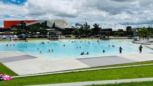 A public swimming pool with people swimming and sunbathing. - Spacious Newly Furnished 4BD Family Retreat (Heathwood)