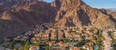 A residential area with houses, roads, and mountains in the background.