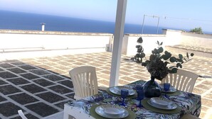 A terrace with a table set for two, overlooking a coastal view. - Apartment with sea view terrace in Salento (Castro)