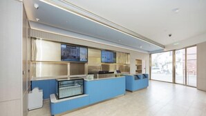 A modern reception area with a blue counter, glass display cases, and digital screens. - HanTing Hotel (Shanghai Jing'an Daning Park) (Shanghai)