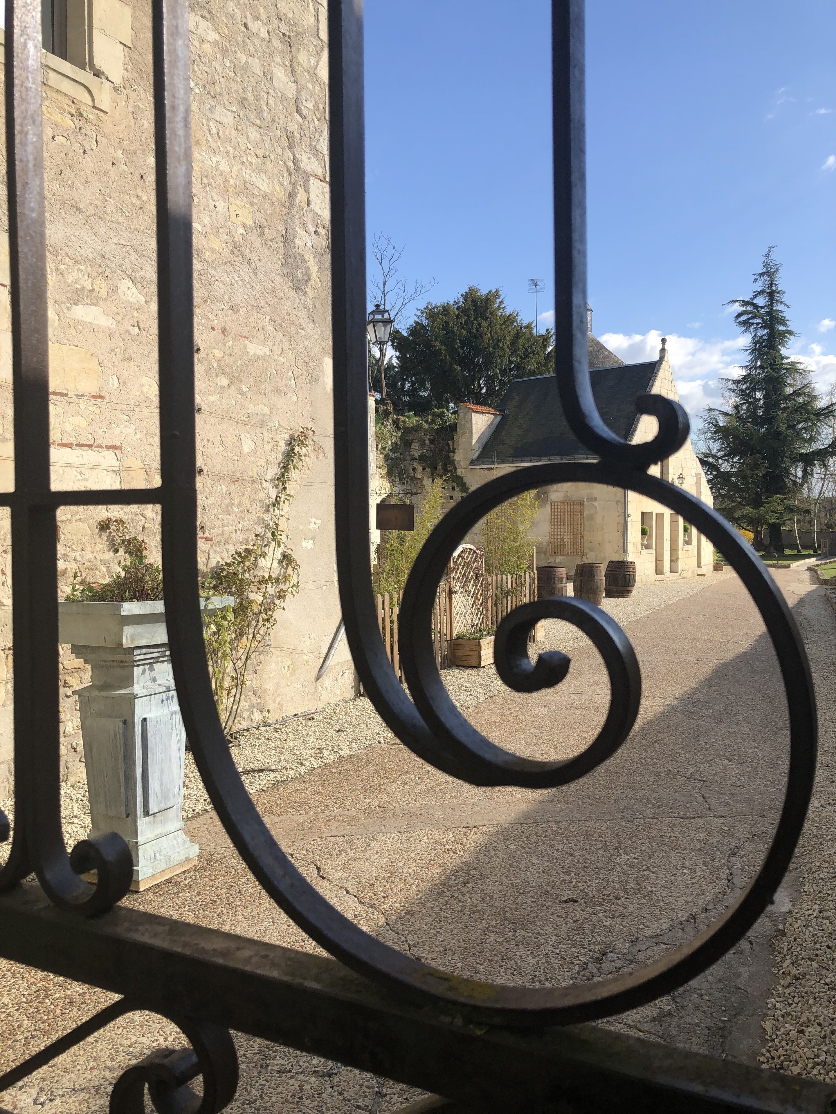 A stone building with a gravel path and metal gate.