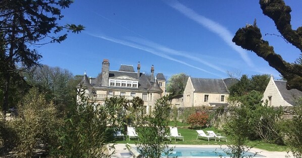 A large estate with a swimming pool, multiple buildings, and a well-maintained garden.