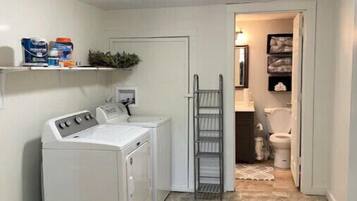 Convenient laundry facilities feature a washing machine and dryer, along with additional storage.