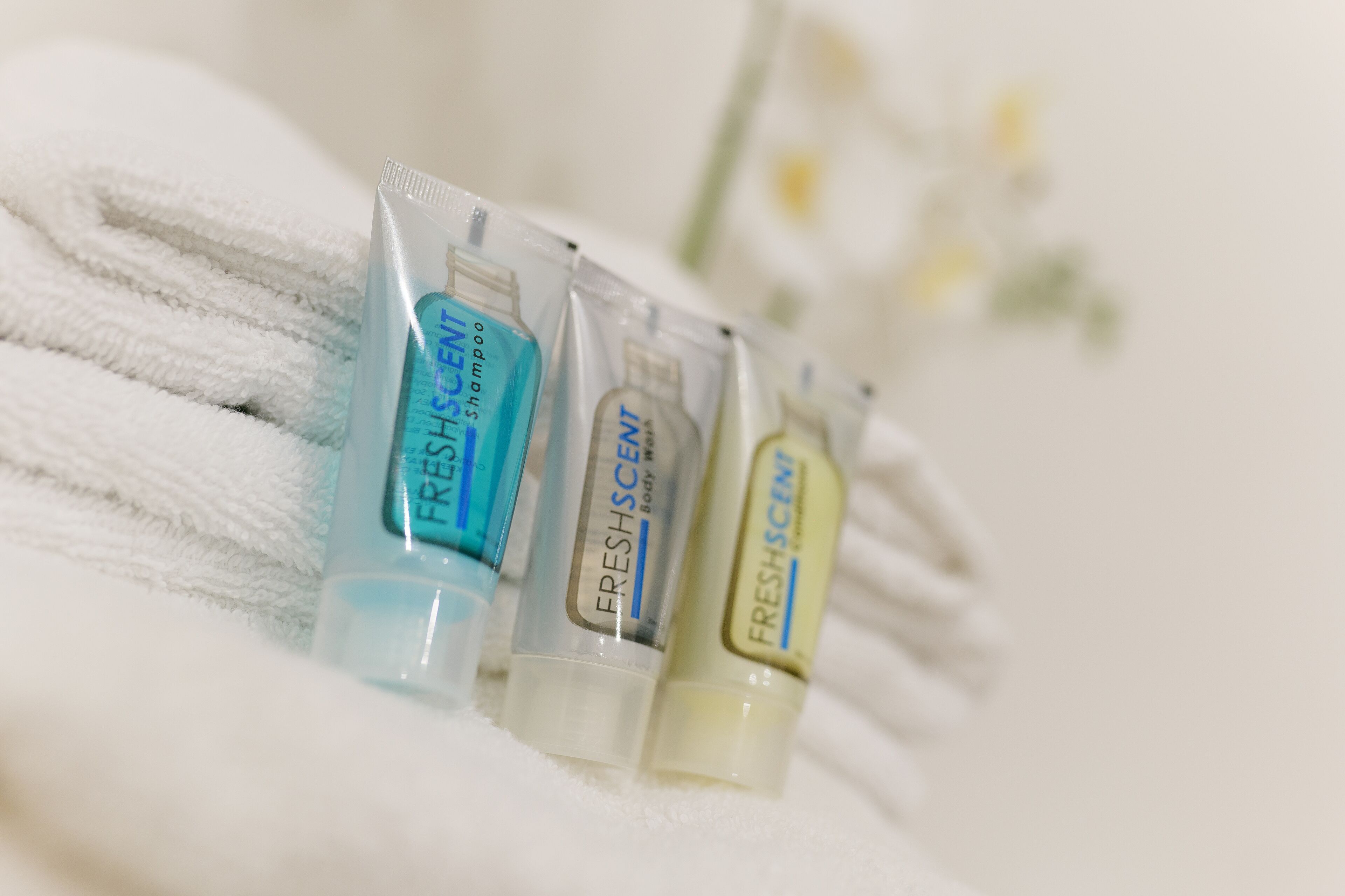 Trois flacons de produits de toilette sur une serviette blanche.