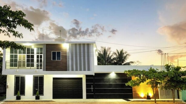 A modern two-story house with a garage, large windows, and a well-lit entrance. - House Valencia 1 (Flores)