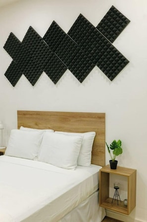 Relax in a serene bedroom with a bed, decorative wall art, and a small nightstand.