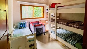 Una habitació amb lliteres, escriptori i finestra.